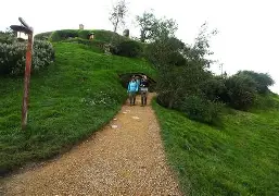 The charming Green Dragon Inn, nestled by a picturesque lake with a running watermill